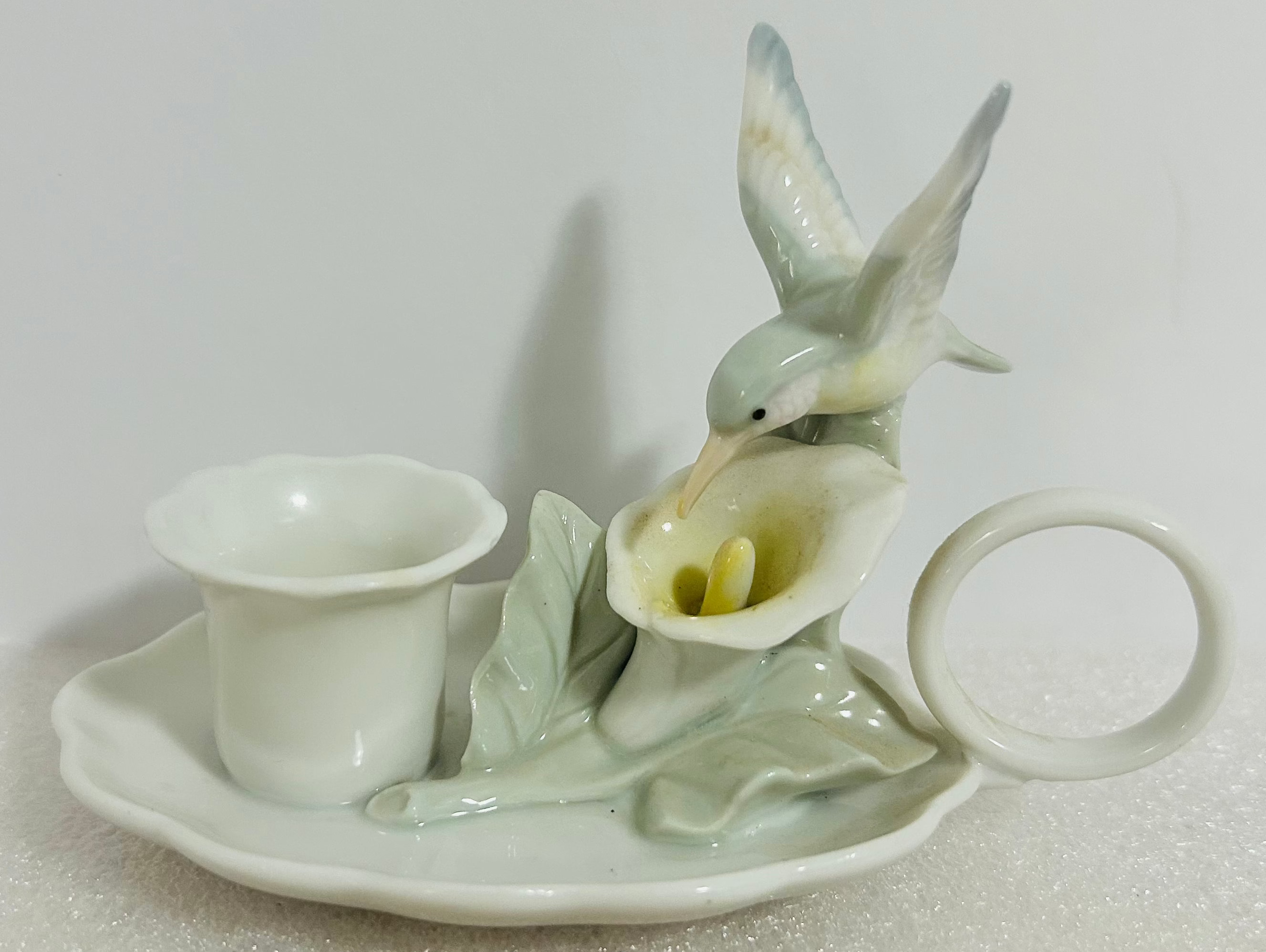 Decorative ceramic piece with a bird and flower design on a white background