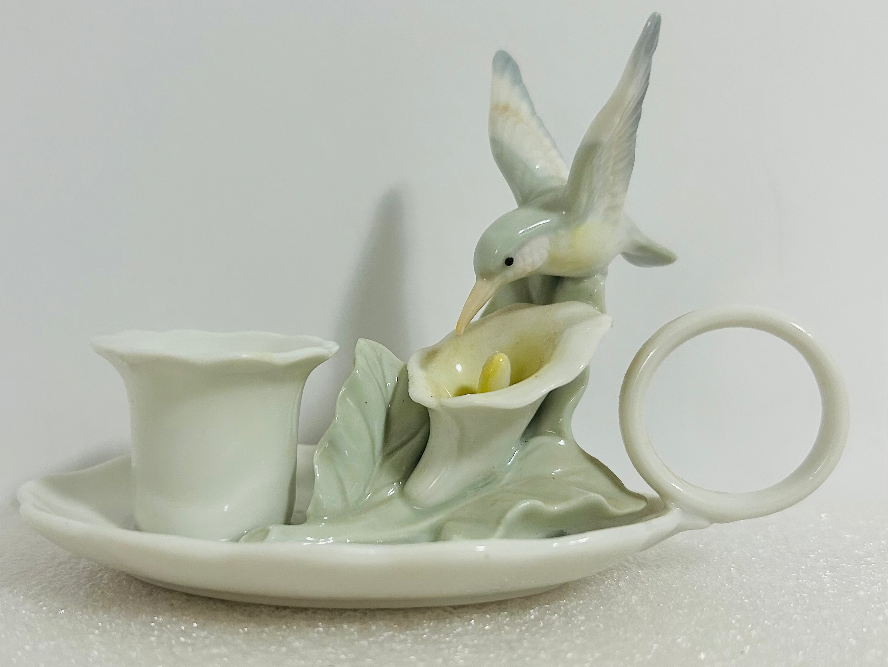 Ceramic teapot with bird design on a plain background