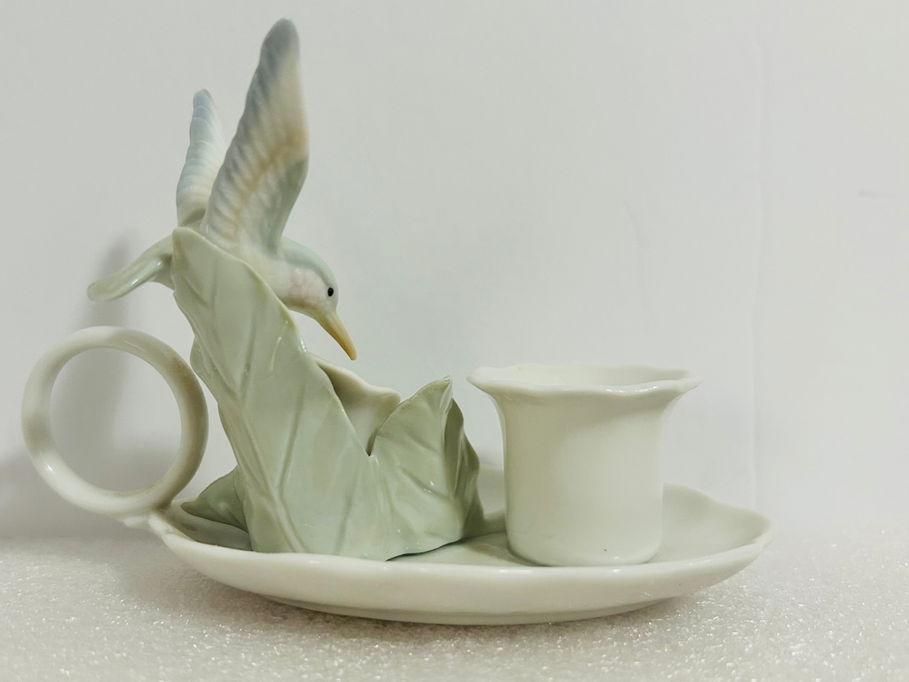 Ceramic teapot with bird design on a white background