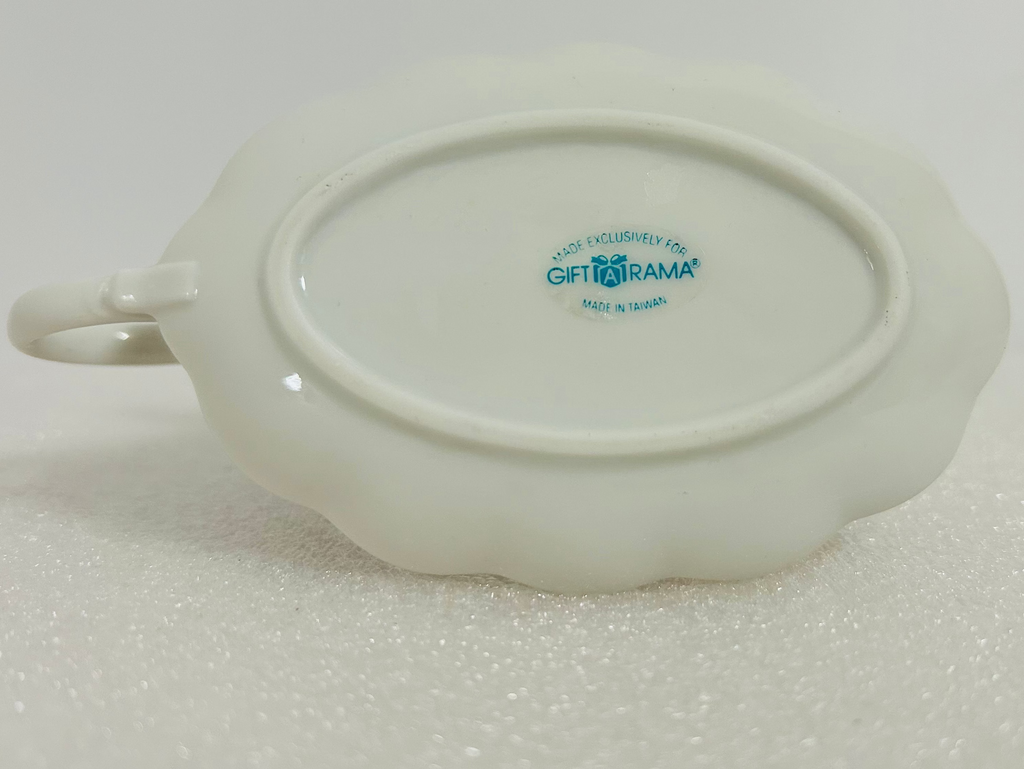 White ceramic dish with a logo on a light gray background