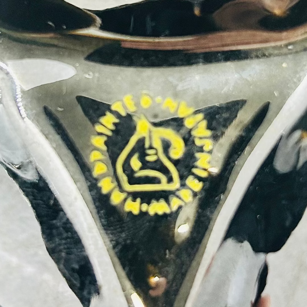 Close-up of a reflective metallic object with a logo on a blurred background